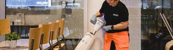 Siivooja Alltimen siivouspalveluissa käyttää yhdistelmäkonetta