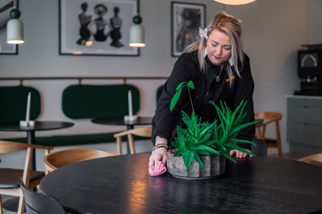 Henkilö pyyhki pöytää toiistossa